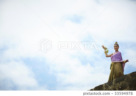 a thai woman is standing and posing in outdoor 33594978