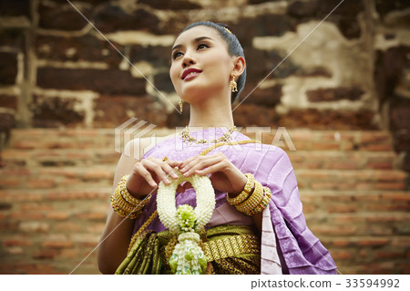 a thai woman is holding a garland and smiling a thai woman is holding a garland and smiling 33594992