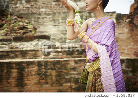 thai woman is holding flower garland in ancient temple thai woman is holding flower garland in ancient temple 33595037