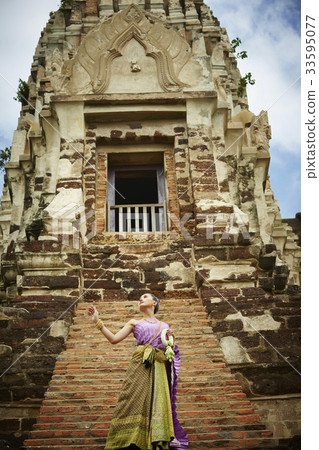 asian woman is standing in front of ancient monument 33595077