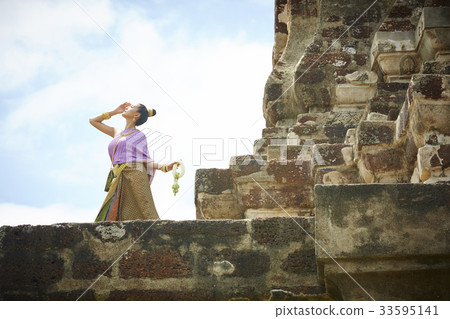 A Thai woman is posing and looking at the sky 33595141