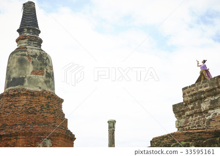 A Thai woman is standing on a high place of a pagoda 33595161