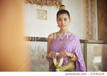 A portrait of Thai woman standing beside the ancient wall. A portrait of Thai woman standing beside the ancient wall. 33595244