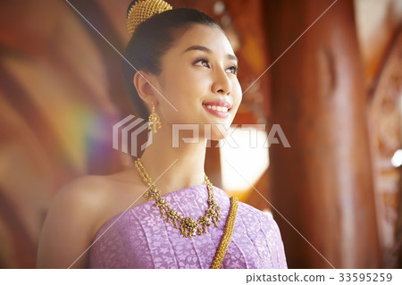 A Thai young woman is smiling under the sunlight. 33595259