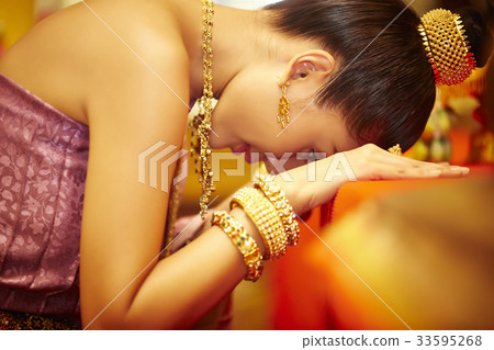 A Thai young woman is praying seriously while her face down on the table. A Thai young woman is praying seriously while her face down on the table. 33595268