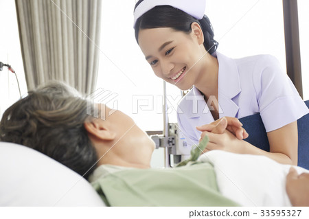 The nurse is holding the patient's hand and smiling 33595327