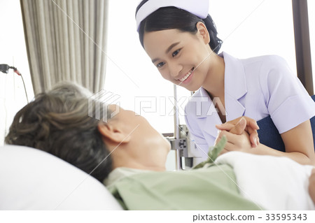 The nurse is holding the elderly patient's hand and smiling The nurse is holding the elderly patient's hand and smiling 33595343