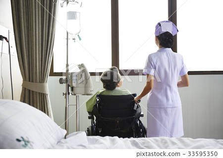 A nurse and an old patient are looking outdoor from the window A nurse and an old patient are looking outdoor from the window 33595350