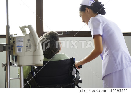 A nurse is taking care of an old patient in a hospital A nurse is taking care of an old patient in a hospital 33595351