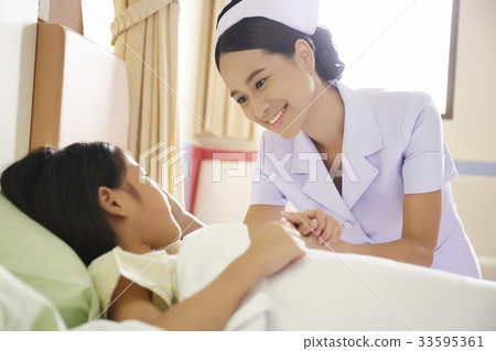 A young nurse is holding hand of a kid patient and smiling A young nurse is holding hand of a kid patient and smiling 33595361