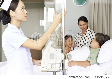 A picture of a nurse checking a saline bottle in a patient's room 33595377