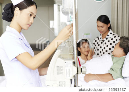 a nurse is checking medical equipment in elderly woman's room a nurse is checking medical equipment in elderly woman's room 33595387