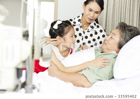 a little girl and her mother are visiting grandmother in hospital 33595402