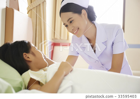 a nurse is smiling and talking to a little girl in clinic a nurse is smiling and talking to a little girl in clinic 33595403