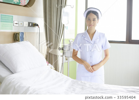 a nurse is standing by the bed in clinic a nurse is standing by the bed in clinic 33595404