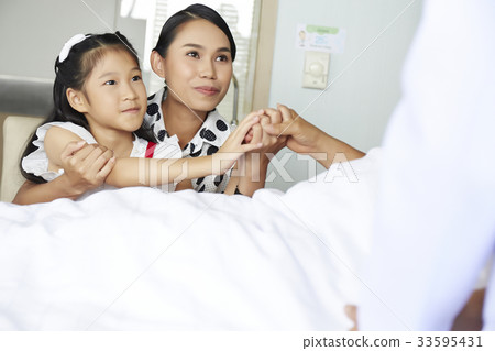 two female people are visiting and holding hand their relative in hospital two female people are visiting and holding hand their relative in hospital 33595431