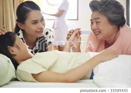 family is sitting with their child in hospital room family is sitting with their child in hospital room 33595435