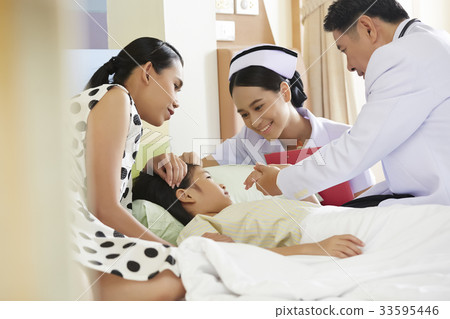 male doctor and nurse are examining a sick girl with her mother at hospital 33595446