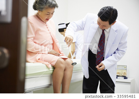doctor is checking knee reflex on senior patient in clinic doctor is checking knee reflex on senior patient in clinic 33595481