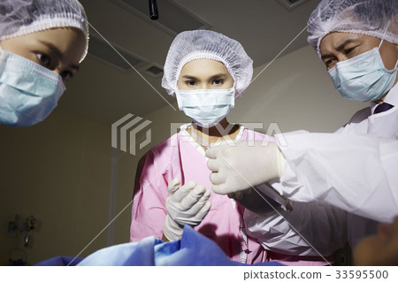 A photo of doctor and nurses doing the surgery operation in room 33595500