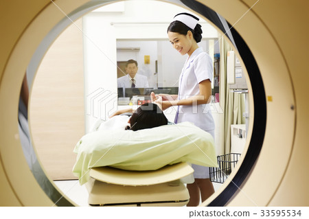 The picture of a nurse preparing to put patient into mri machine 33595534