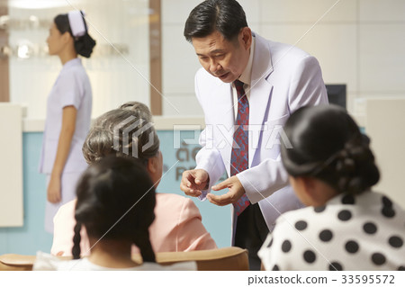 A photo of a doctor talking to an elderly patient in the hospital. A photo of a doctor talking to an elderly patient in the hospital. 33595572