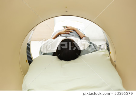 A photo of an Asian young patient going through CT. 33595579