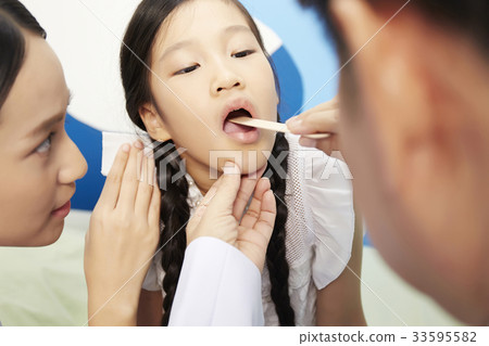 the doctor is examining the mouth of the kid patient the doctor is examining the mouth of the kid patient 33595582