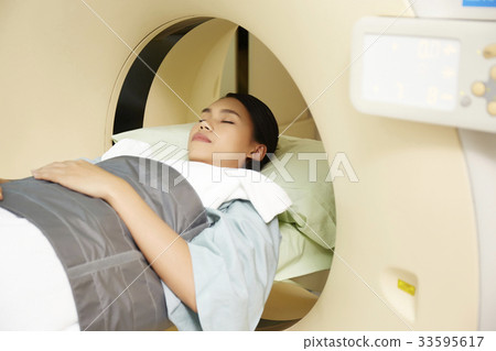 a photo of a girl lying and preparing to go through CT 33595617
