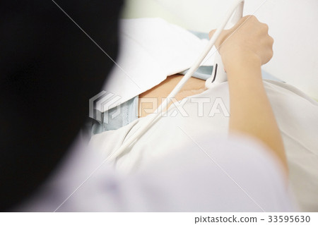 a nurse is holding the scanner and checking her patient a nurse is holding the scanner and checking her patient 33595630