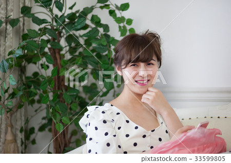 在沙發上使用智能手機的年輕女士 33599805