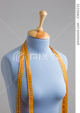 Blue tailor dummy with measuring tape alongside Blue tailor dummy with measuring tape alongside 33602232
