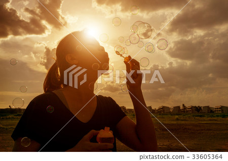 A South East Asian girl is blowing bubbles 33605364