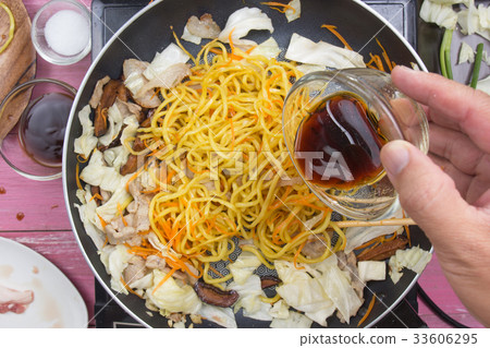 Chef pouring soy sauce for cooking Yakisoba noodle Chef pouring soy sauce for cooking Yakisoba noodle 33606295