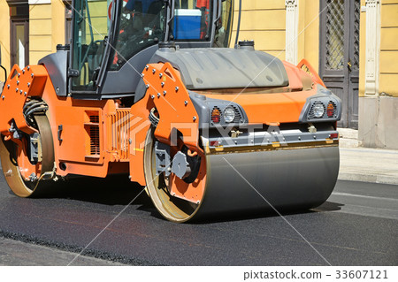 Road roller at work on the street 33607121
