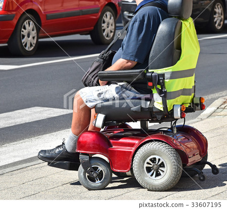 Man sits in an electric wheelchair 33607195