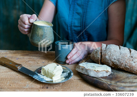 Woman has breakfast adds milk to coffee 33607239