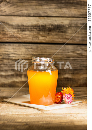 The bowl with honey on wooden table.The bank of 33607777