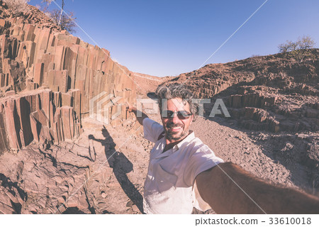 man taking selfie at volcanic rock formation 33610018