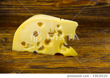 Piece of cheese on the wooden background Piece of cheese on the wooden background 33610520