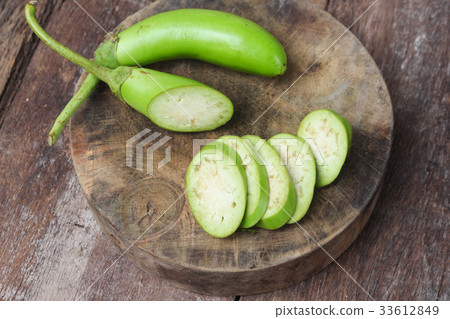 Fresh Eggplants, one cut in slices on a wooden 33612849