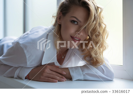 Gorgeous sexy blonde lying on window sill portrait 33616017