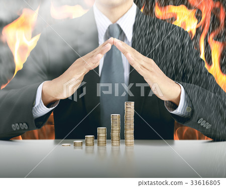 businessman hand cover money stack with fire  33616805