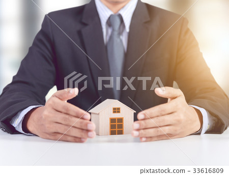 businessman hand cover wooden home model 33616809