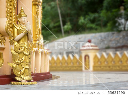 Statue of an angel standing in front of a pagoda. Statue of an angel standing in front of a pagoda. 33621290