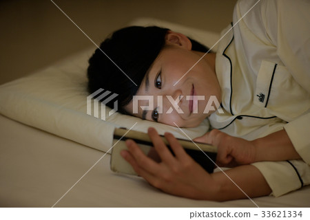 Woman looking at smartphone in futon 33621334
