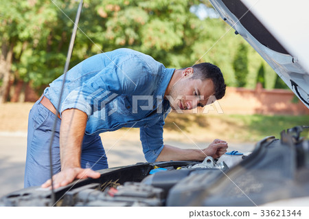 Man standing in front of a broken car 33621344