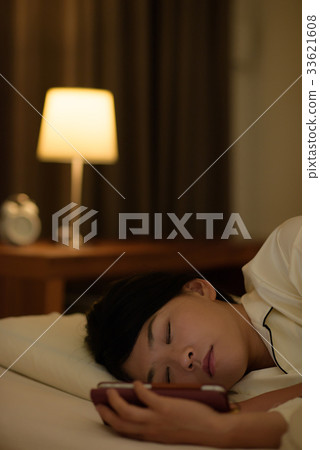 Woman looking at smartphone in futon 33621608
