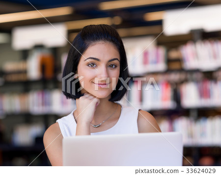 Happy female student at the library 33624029