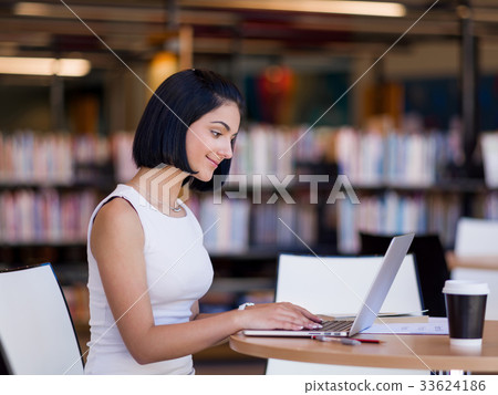 Happy female student at the library Happy female student at the library 33624186